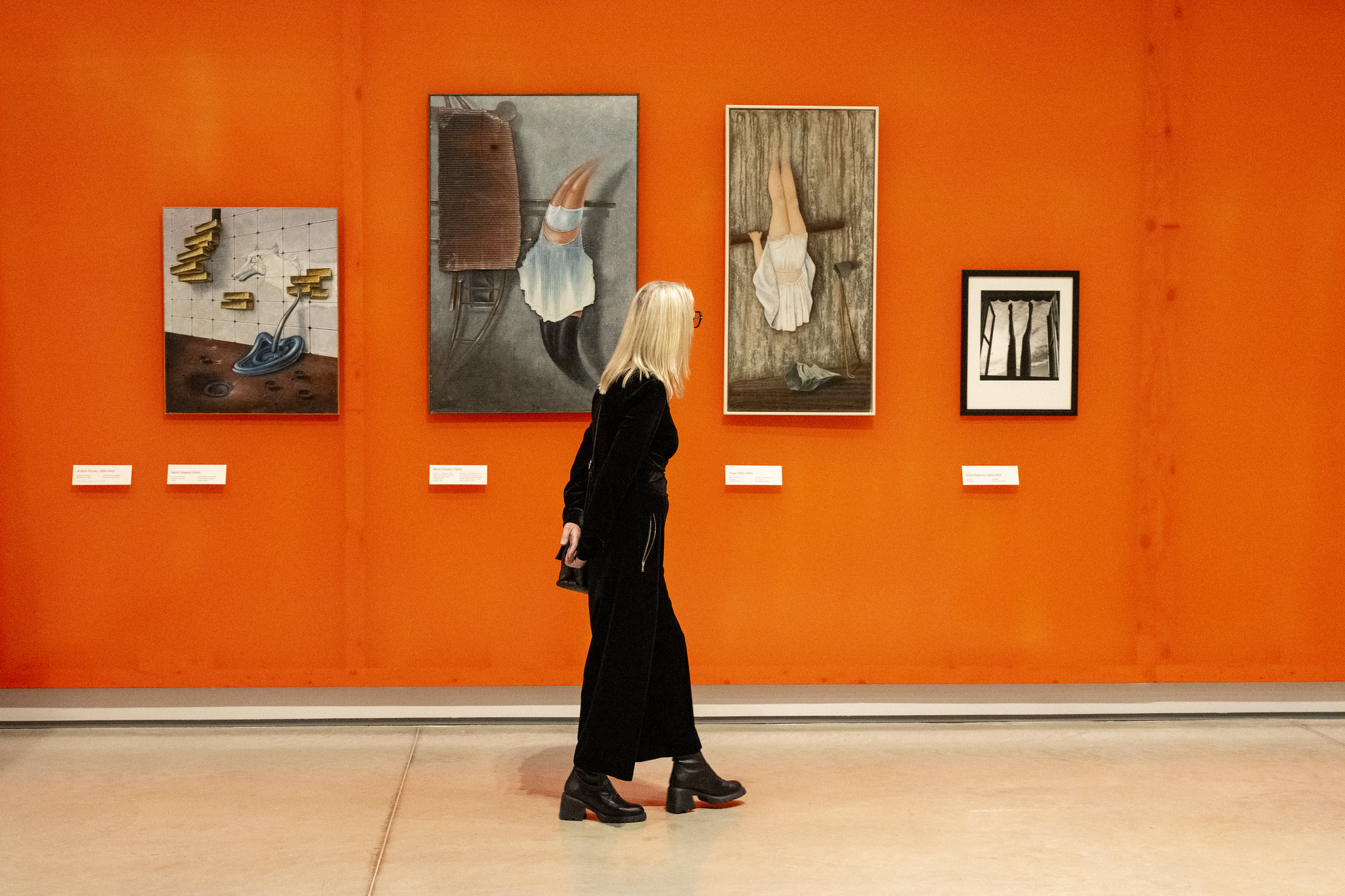 Woman looking at surrealist artworks.