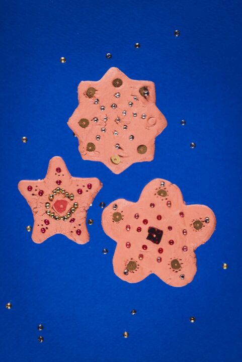 Kolm savist tähe- ja lillekujulist kujukest, mille peale on pandud pärlid.